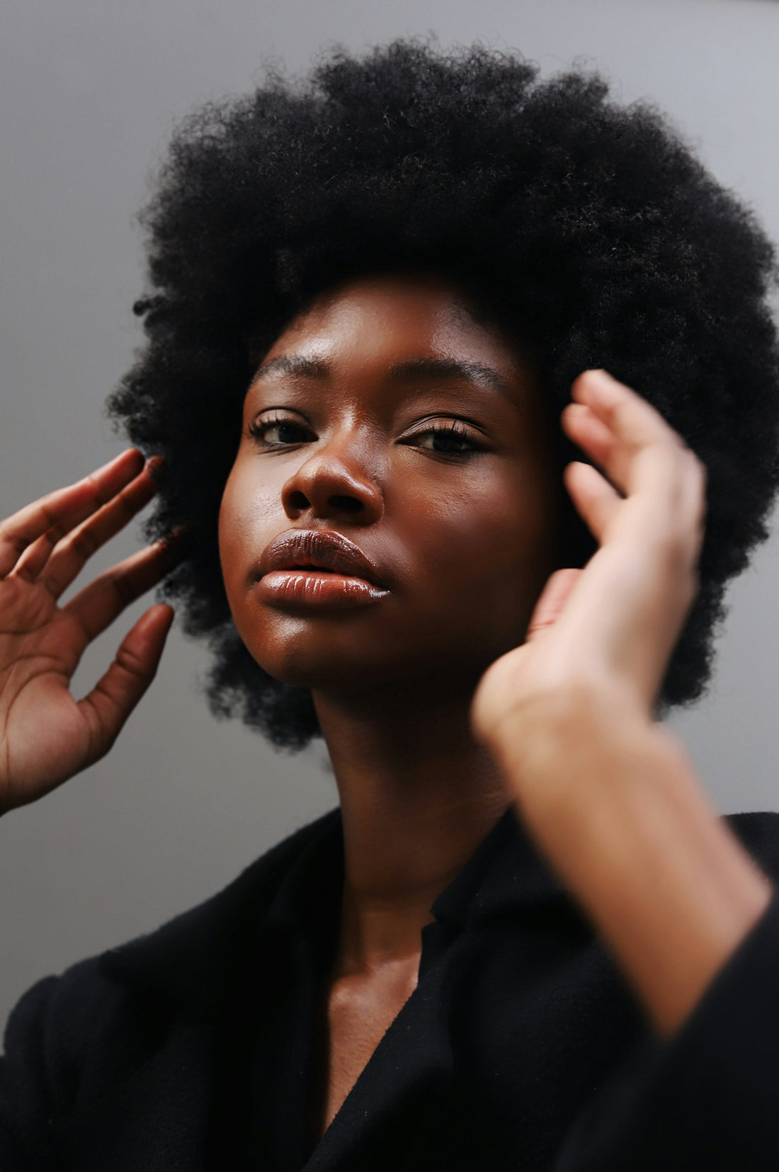Woman with natural afro hair combing her hair