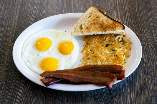 A high-calorie breakfast plate with eggs, bacon and toast