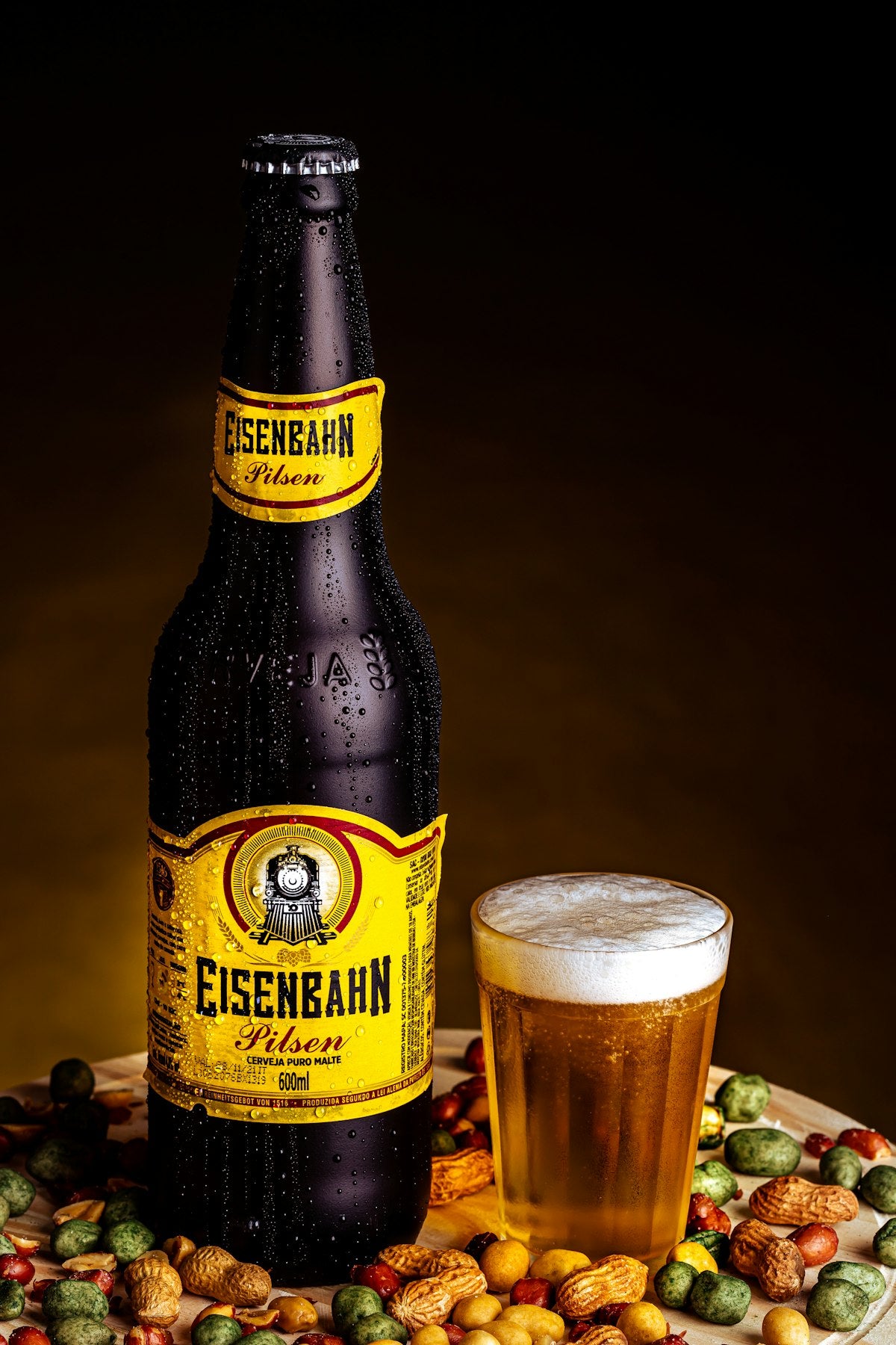 Brown glass bottle of dark malt drink with a glass