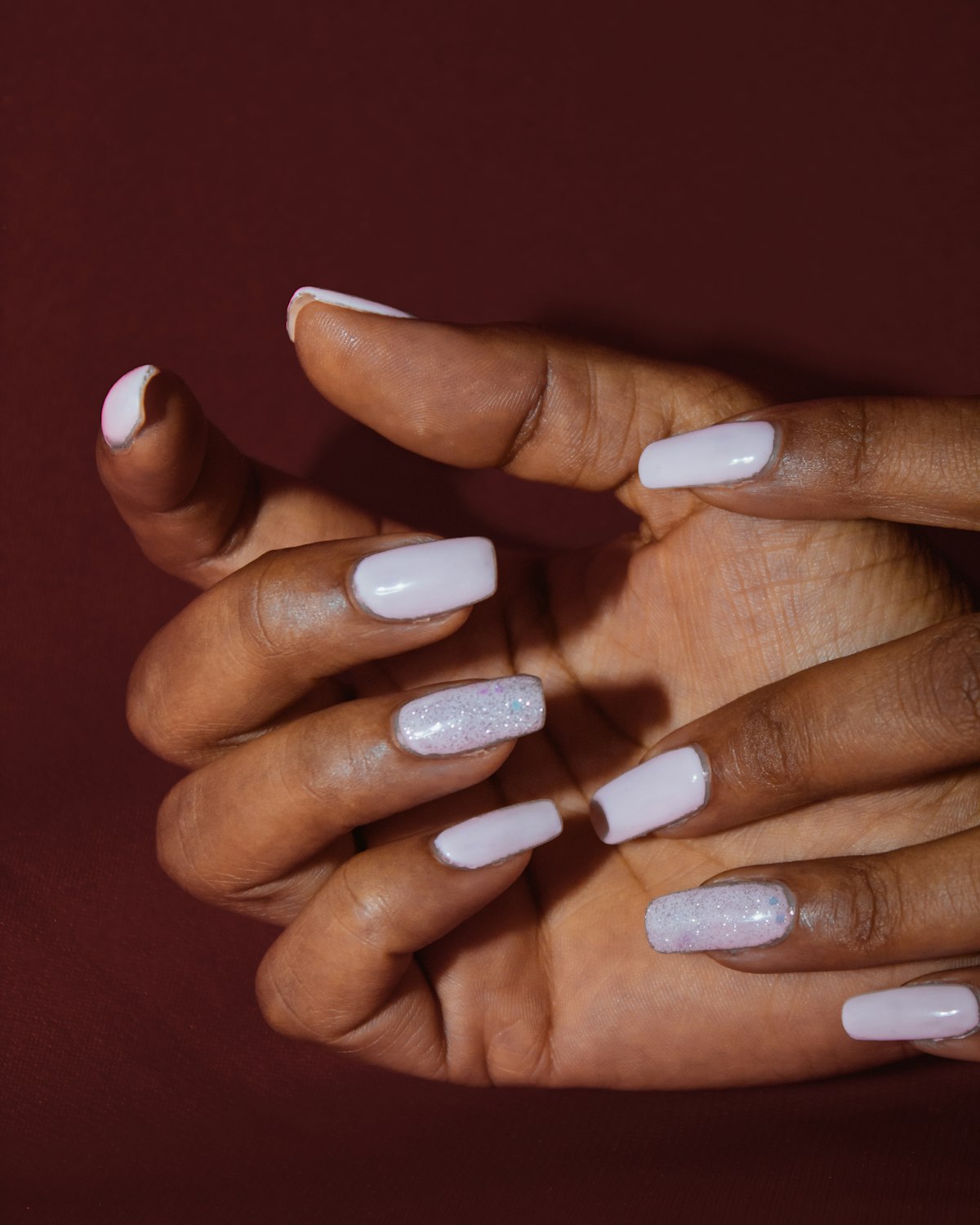 Manicured hands with white nails
