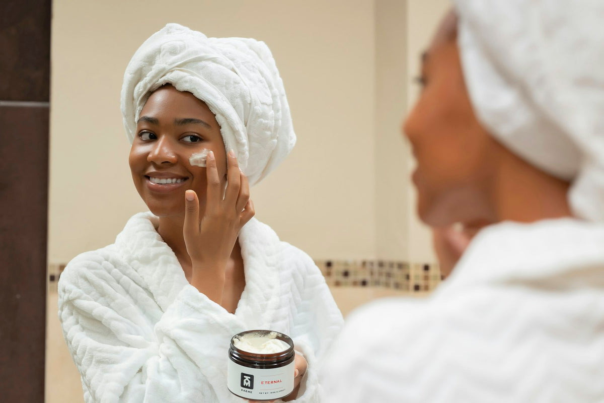 Woman with a towel on her head applying cream